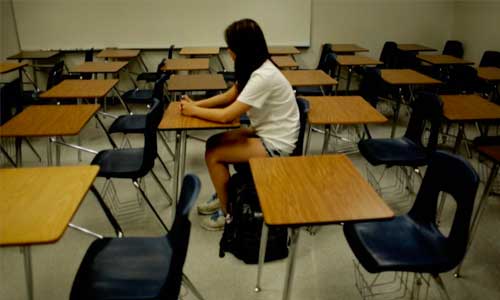 korean college girl sits alone in a classroom