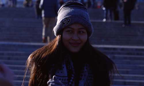 Young Burmese woman standing on a outdoor staircase smiling