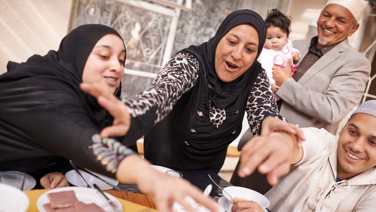 muslim refugee family playful enjoying a meal together
