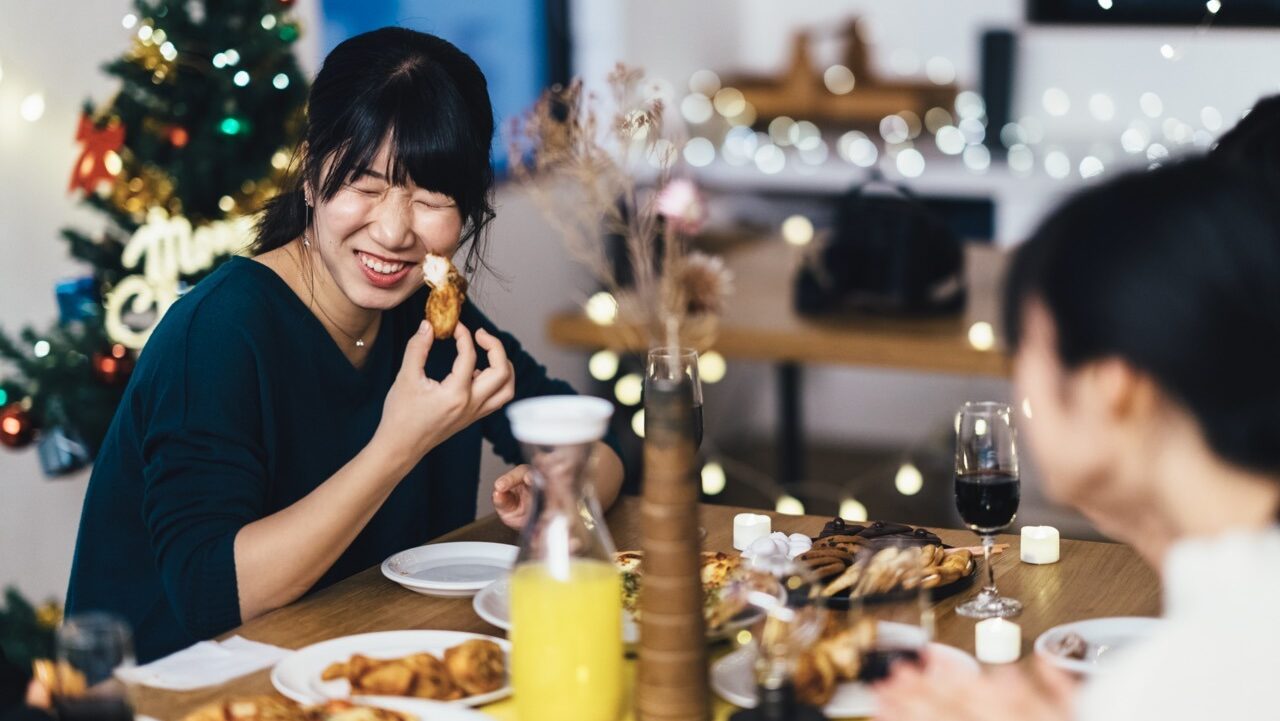 international student laughs while sharing a holiday meal with friends