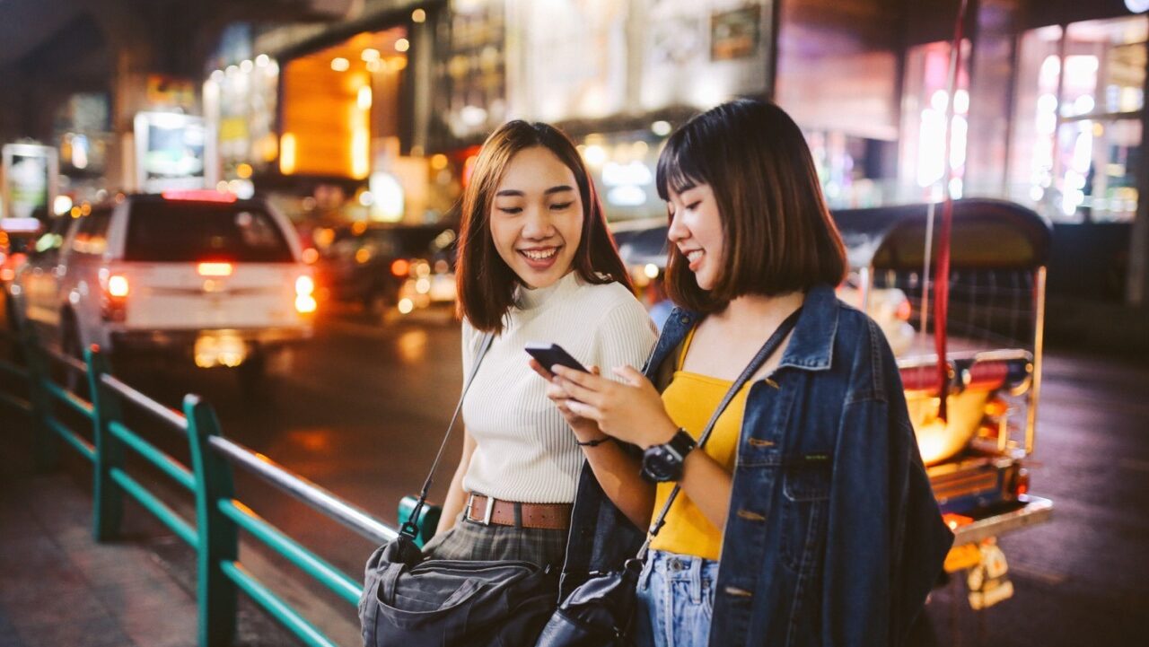 two young Thai women chatting on the streets of Bangkok